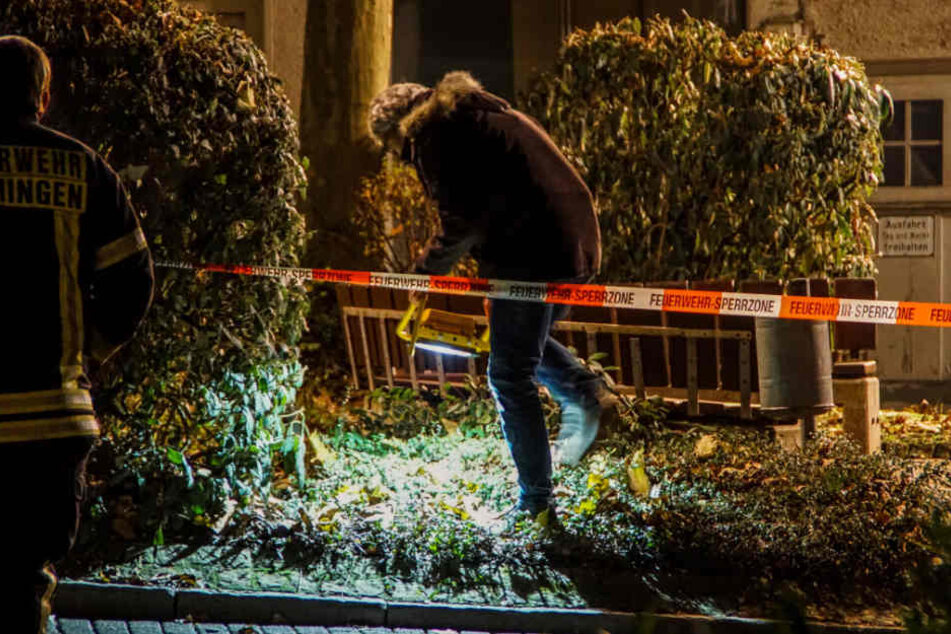 Ermittler untersuchen den Tatort, nachdem ein Mann von einem Auto aus auf offener Straße erschossen worden ist.