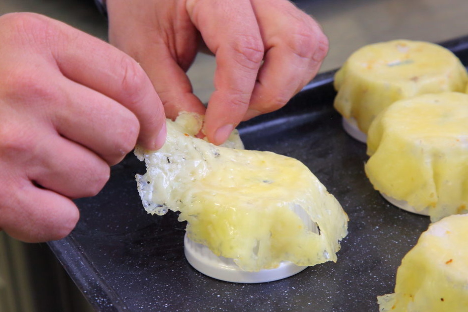 Mit viel Fingerspitzengefühl modelliert der Gourmetkoch die Käsetörtchen.