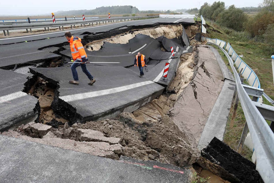Fachleute begutachten das abgesackte Autobahnteilstück.
