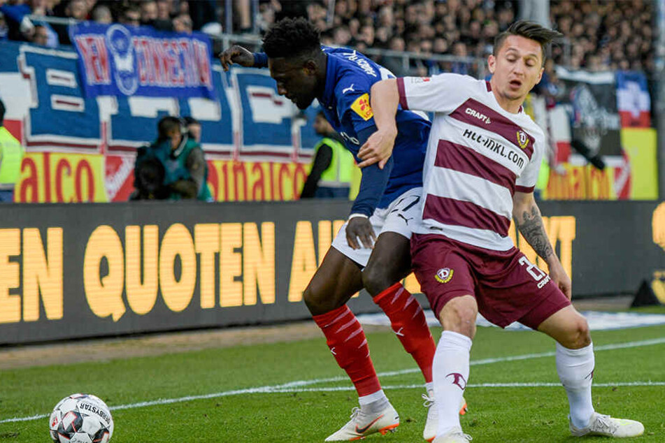 Kiels Kingsley Schindler (l) und Dresdens Baris Atik kämpfen um den Ball.