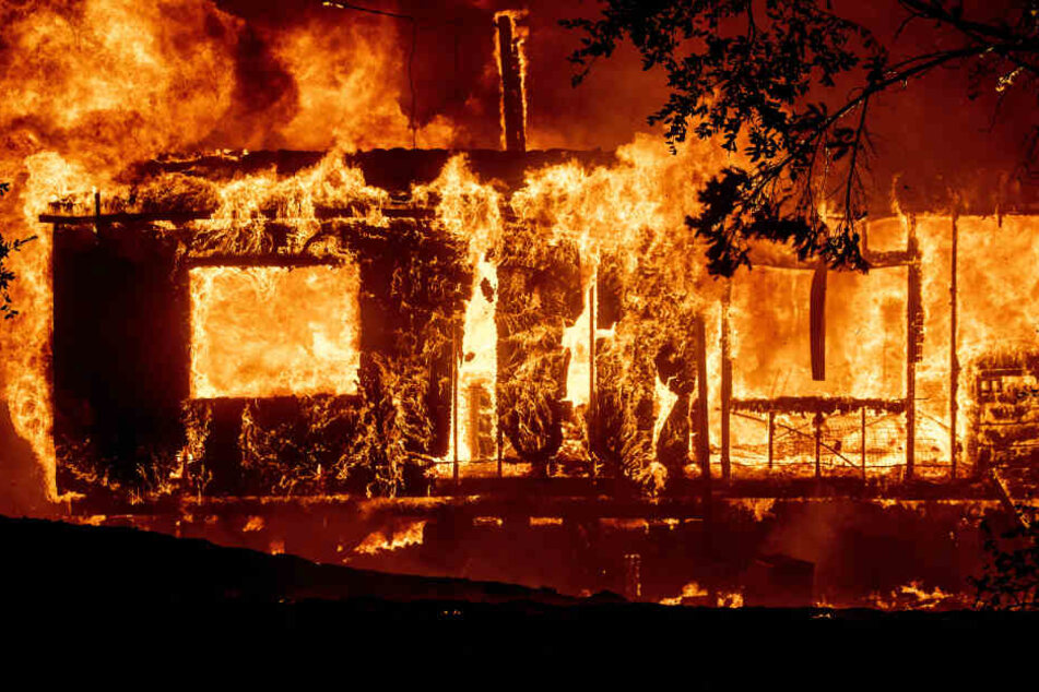 Ein Haus brennt lichterloh, während sich ein Waldbrand im US-Bundesstaat Kalifornien aufgrund starker Winde weiter ausbreitet.