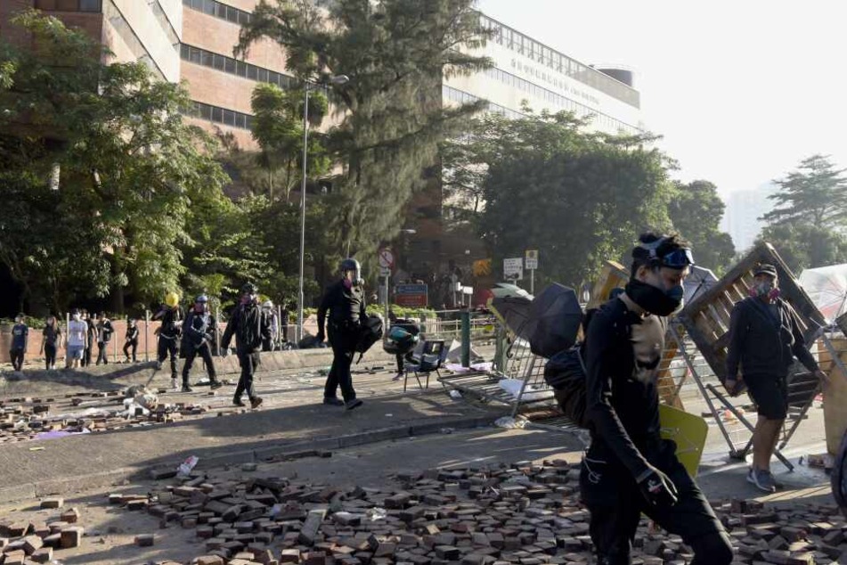 Demonstranten verlassen die Polytechnische Universität im Bezirk Kowloon nach heftigen Auseinandersetzungen mit der Polizei.