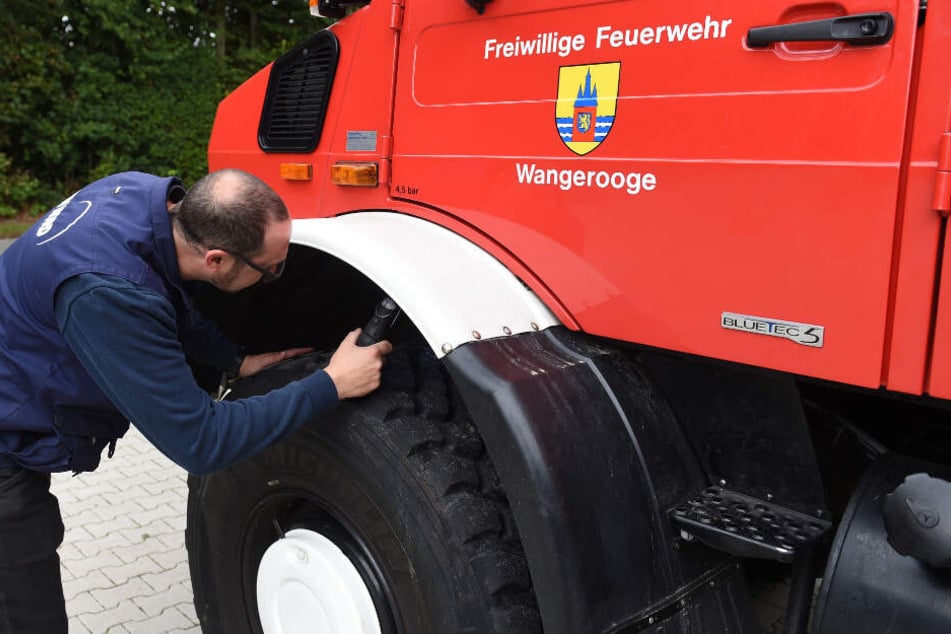 Ein Mitarbeiter überprüft das Feuerwehrfahrzeug.
