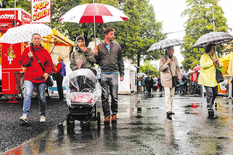Regenkleidung und Regenschirme sind unabdingbar, um auf dem Volksfest zu bestehen.