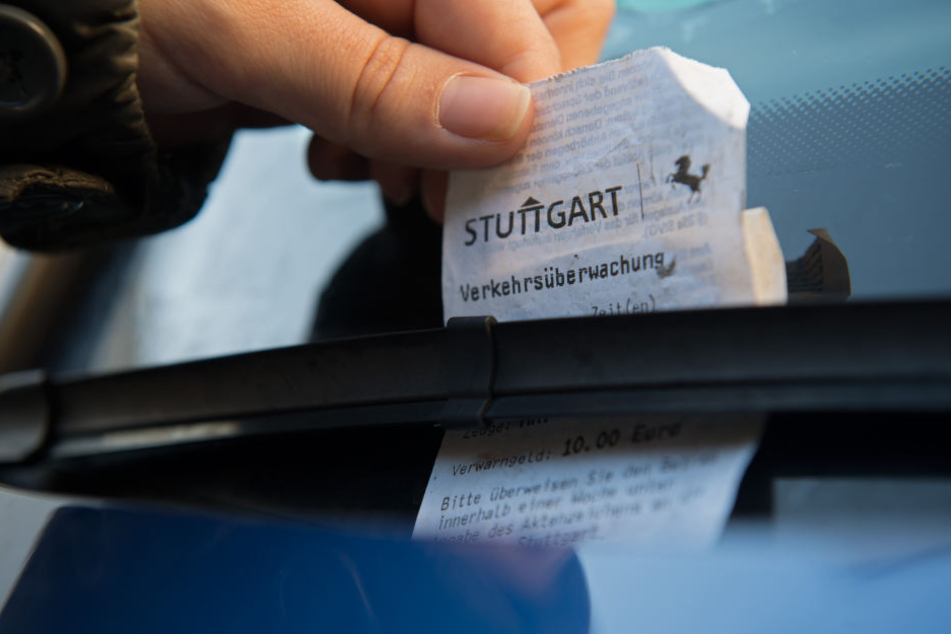 Ein Strafzettel der Verkehrsüberwachung der Stadt steckt am hinter dem Scheibenwischer eines PKWs. (Symbolbild)