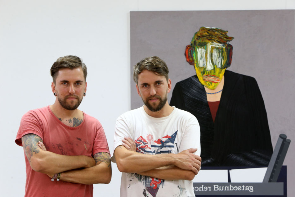 Die Künstler-Zwillinge Marcel (r.) und Robby Oertel (37) aus Kuhschnappel neben einem Gemälde mit einem ihrer Arbeitszombies.