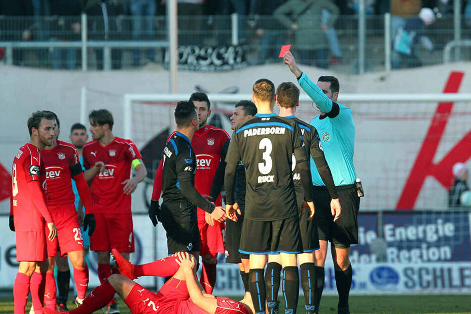 Schiedsrichter Felix-Benjamin Schwermer zeigt Niko Dobros nach einem Foul an Patrick Wolf die rote Karte.
