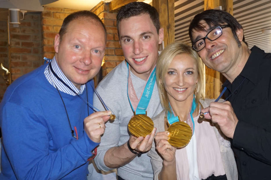 Die Eiskunstläufer Aljona Savchenko und Bruno Massot überreichen im April 2018 ihren Trainern Alexander König (l) und Jean-Francois Ballester (r) extra angefertigte Replikas ihrer olympischen Goldmedaillen.