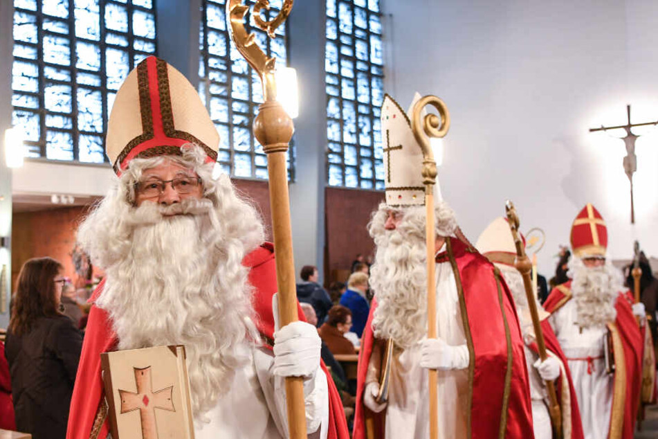 Sechs verkleidete Nikoläuse ziehen aus der Kirche aus.