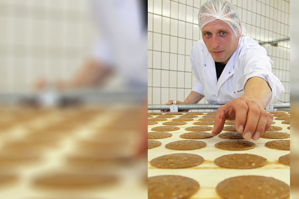 Ein Mitarbeiter der Lebkuchenfabrik Ferdinand Wolff GmbH in Nürnberg entnimmt zu Kontroll-Zwecken noch nicht gebackene Oblaten-Lebkuchen vom Förderband.