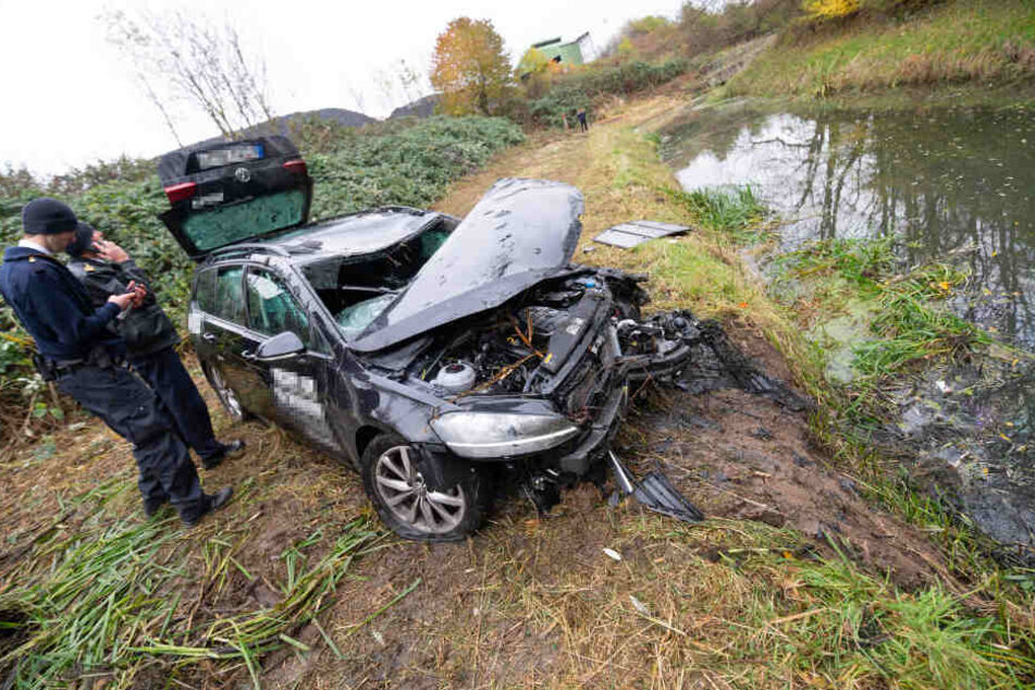 Feuerwehrleute haben das zerstörte Auto aus dem Wasser geborgen.