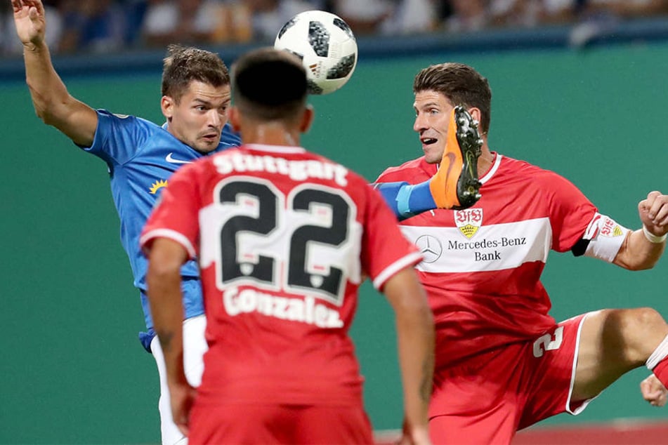 Der Rostocker Julian Riedel (links) und der Stuttgarter Mario Gomez (rechts) im Zweikampf, der Stuttgarter Nicolas Gonzalez (Mitte) verfolgt die Szene.