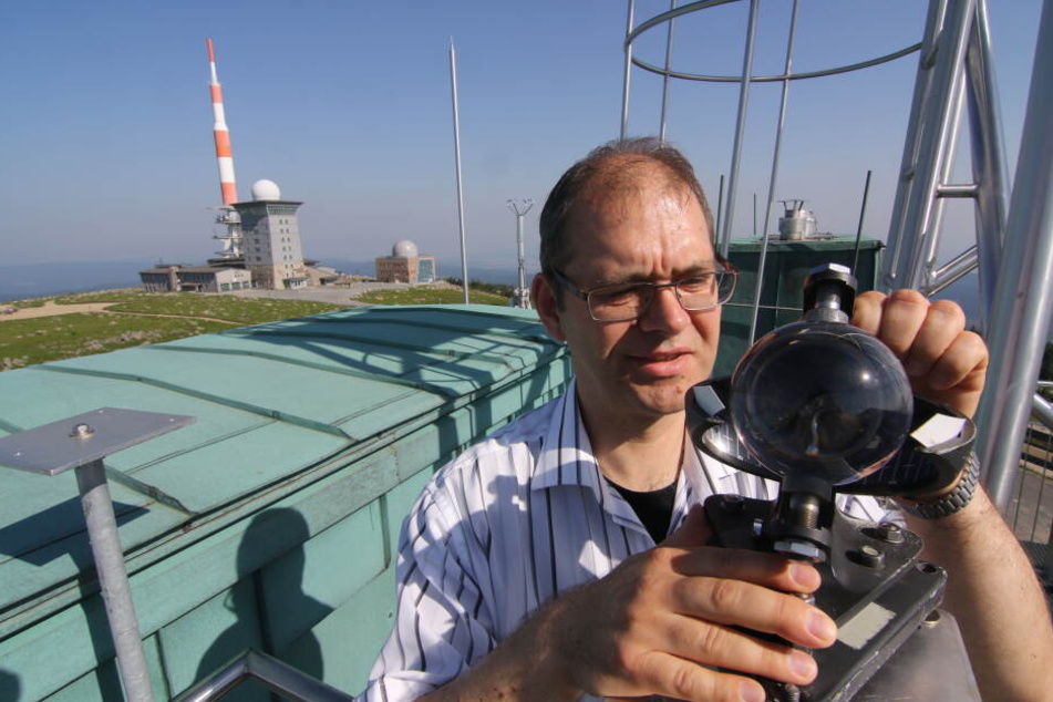 Wetterbeobachter Michael Wellmann liest auf dem Dach der Wetterwarte Brocken den Sonnenscheinautographen ab.