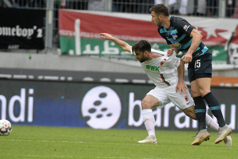 Jan Moravek (l) von Augsburg und Marko Grujic von Berlin kämpfen um den Ball.