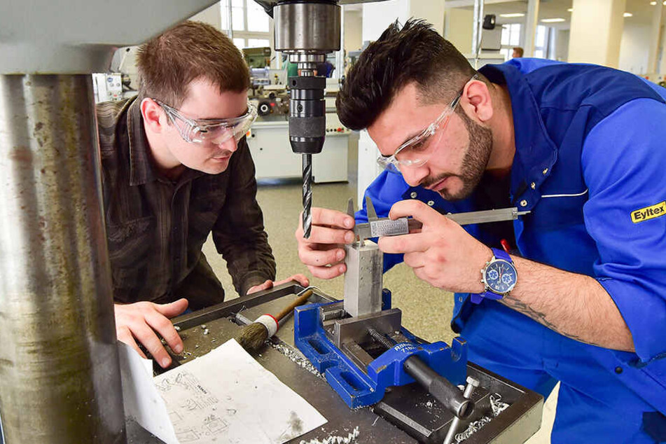 Der Syrer Mahmoud Mustafa (r.) bearbeitet im Ausbildungszentrum unter Anleitung von Rayk Wieland ein Werkstück.