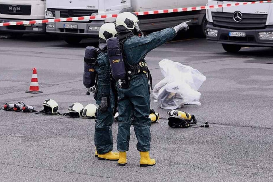 Zwei Feuerwehrmänner mit Schutzanzügen an der Einsatzstelle.