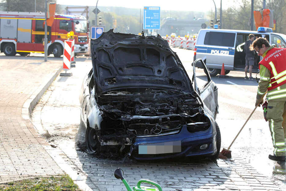 Der Mercedes brannte komplett aus. Ein Mitarbeiter der Feuerwehr versucht hier, die Spuren des Löschens zu beseitigen.