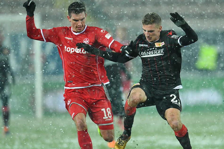 Christoph Moritz (l) will Unions Grischa Prömel im Schneegestöber den Ball abnehmen.