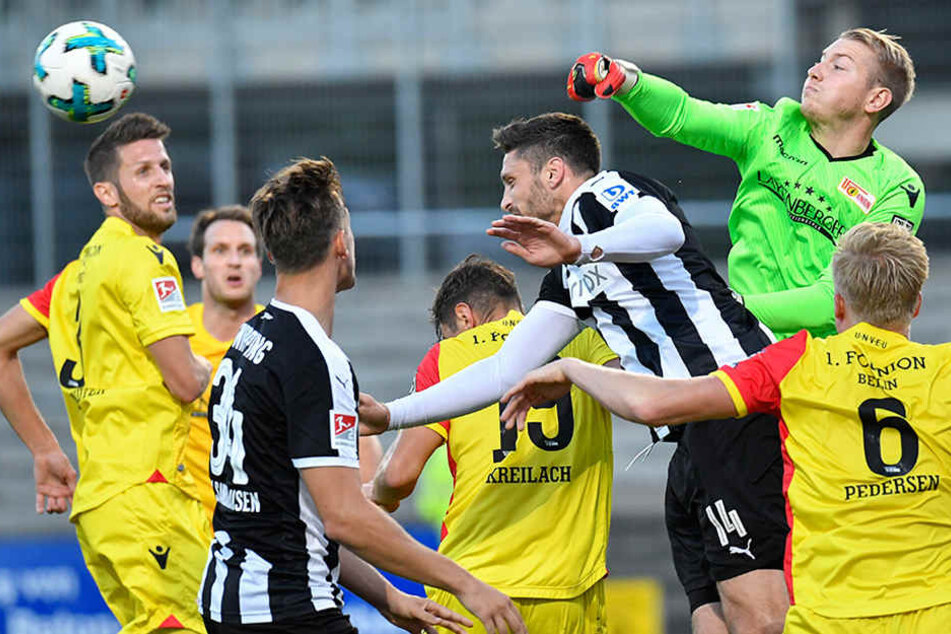 Sandhausens Tim Kister (3.v.r.) und Unions Torwart Jakob Busk (2.v.r.) kämpfen um den Ball.