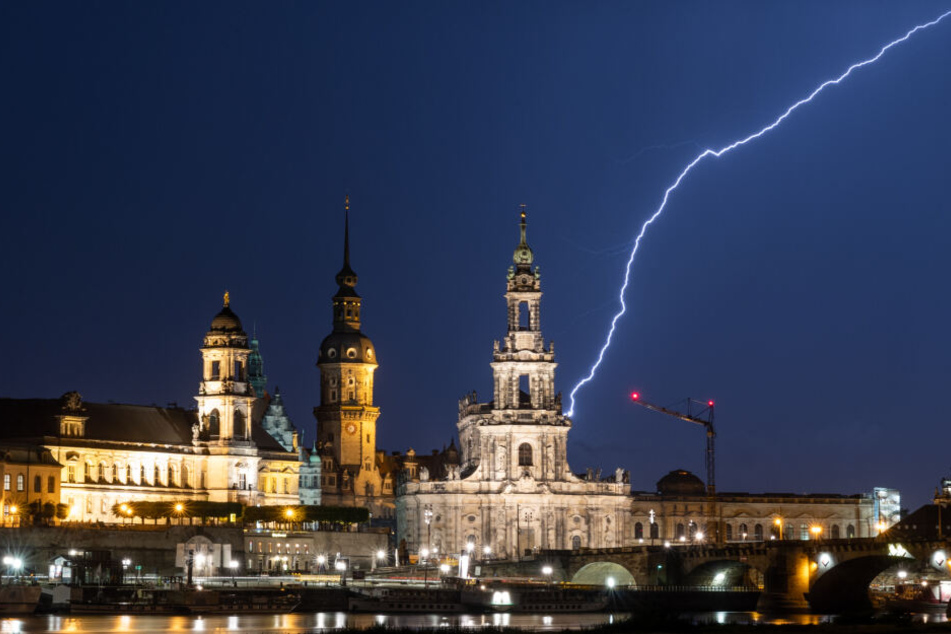 Blitze schlagen während eines Gewitters am Abend in die historische Altstadtkulisse in Dresden ein.