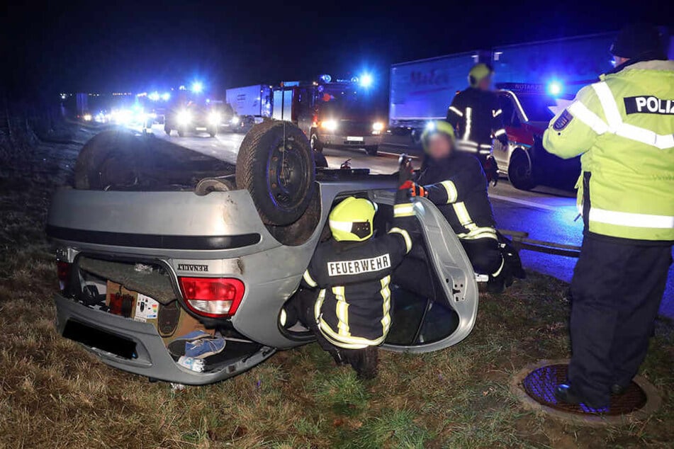 Die Feuerwehrleute sichern das verunfallte Auto.