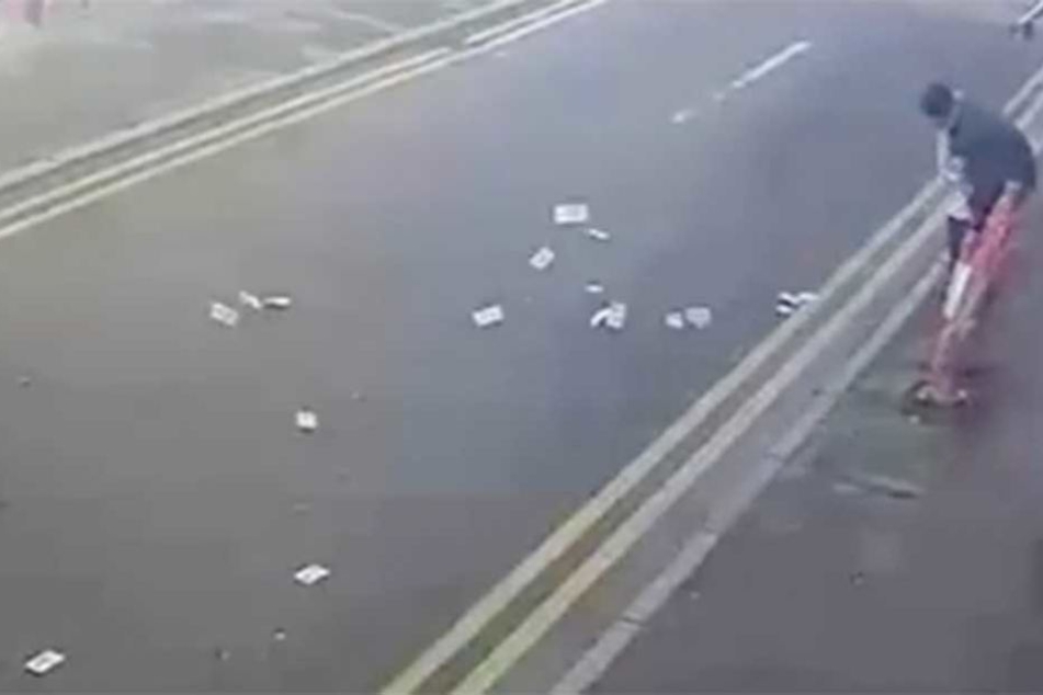 Die Geldscheine werden die Straße entlang geweht.