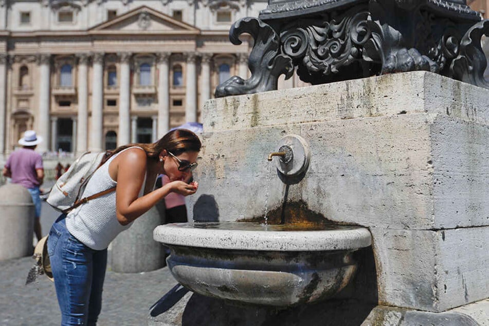 Auch in Rom war es heiß. Eine Touristin erfrischt sich an einem Trinkbrunnen.