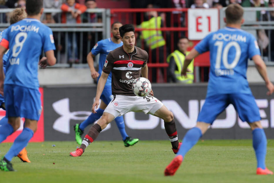 YiYoung Park schirmt den Ball vor seinen Gegenspielern ab.
