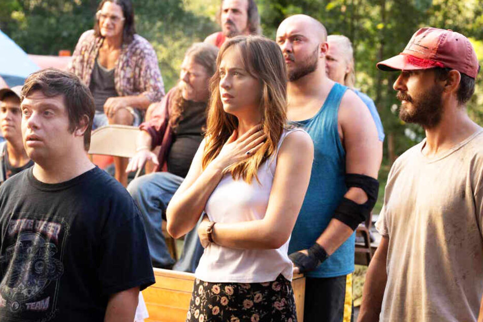 Tyler (r., Shia LaBeouf), Zak (l., Zack Gottsagen) und Eleanor (Dakota Johnson) schauen bei einem Hinterhof-Wrestling-Turnier zu.