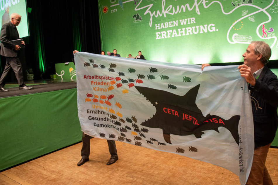 Winfried Kretschmann (links im Bild) geht auf dem Landesparteitag der Grünen in Sindelfingen von der Bühne und passiert Demonstranten.