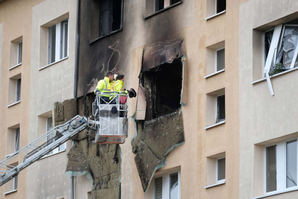 Ermittler schauen sich die zerstörte Wohnung über eine Drehleiter von außen an. Noch immer ist nicht geklärt, ob der Mieter selbst für die Explosion verantwortlich ist.