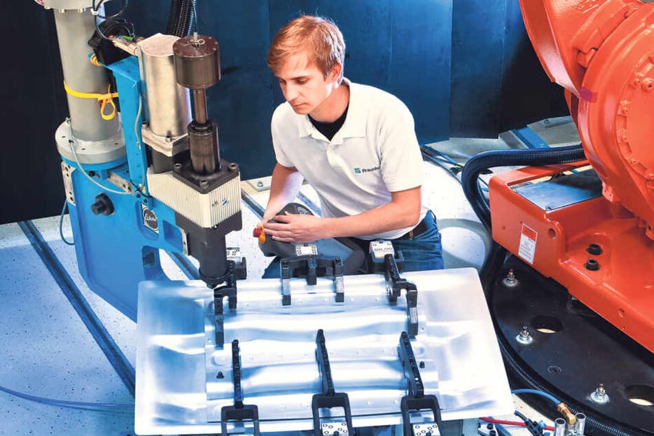Das geht bisher nur am Fraunhofer-Institut: Mitarbeiter Christian Kraus
arbeitet Hand in Hand mit einem Industrieroboter.