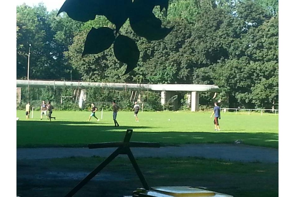 Illegales Fußballspiel in Markersdorf: Junge Männer klettern über den Zaun zum Kicken.