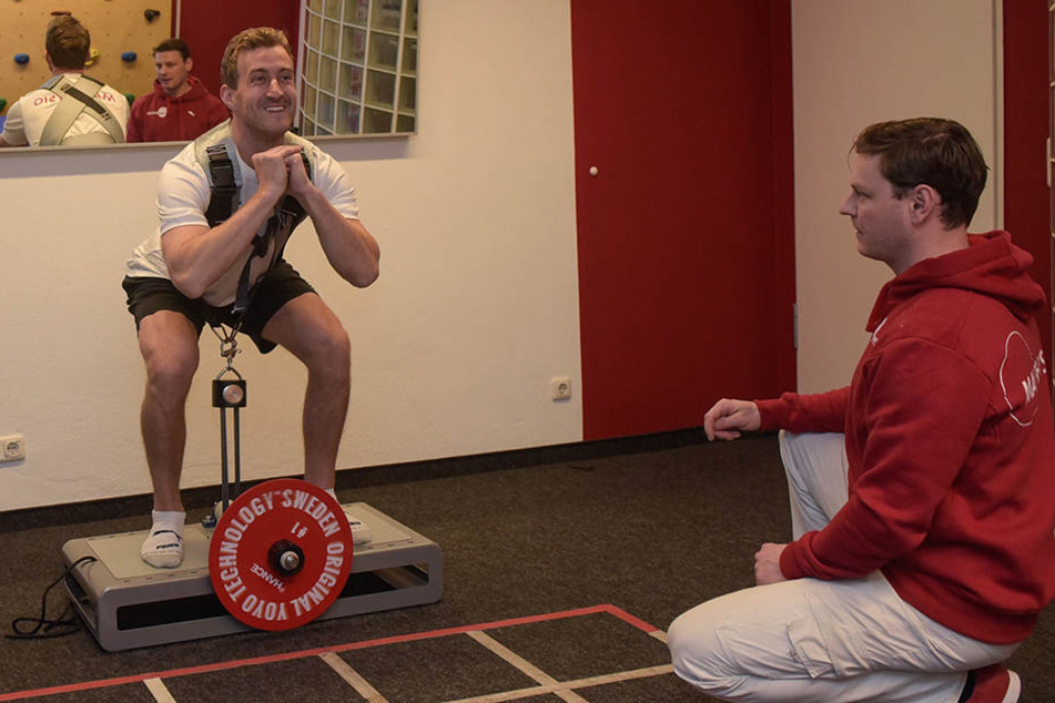 Harrison Reed trainiert auf diesem Gerät
die Kraft. Er muss sich unter Aufsicht von
Physiotherapeut René Wallner hochdrücken und anschließend gegen den Druck
wieder in die Hocke nach unten bewegen.