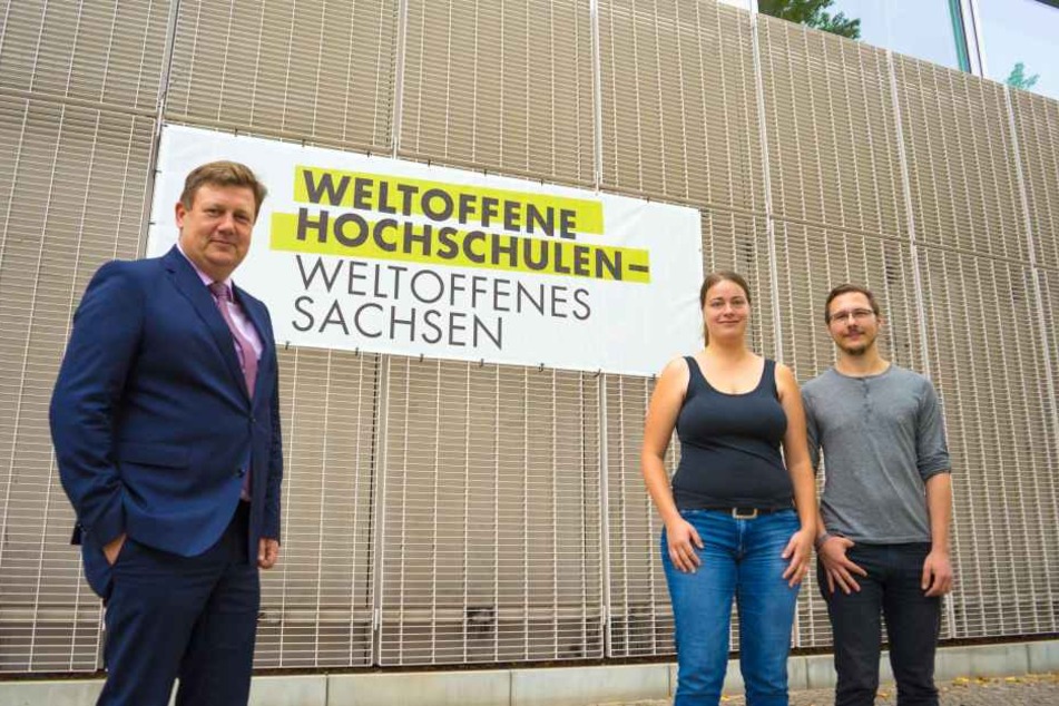 Gemeinsam mit Prof. Markus Krabbes stehen die HTWK-Studierenden Marie Hartung und Toni Nabrotzky vor dem am Nieper-Bau platzierten Banner sinnbildlich für das Selbstverständnis der Einrichtung als „Weltoffene Hochschule".