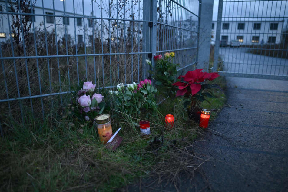 Blumen und Kerzen stehen am Eingang zu einer kommunalen Unterkunft, in der neben Flüchtlingen auch Obdachlose untergebracht sind.