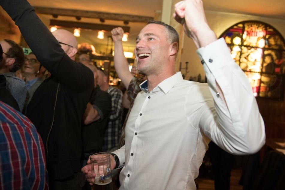 Sebastian Wippel, AfD-Landtagsabgeordneter und Oberbürgermeisterkandidat für Görlitz, jubelt während einer Wahlparty seiner Partei in einer Gaststätte.