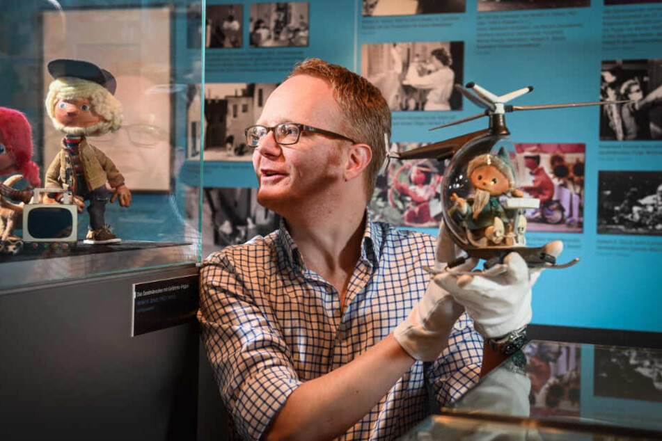 Till Grahl (41) vom Deutschen Institut für Animationsfilm mit den beiden Herrschaften: links der BRD-Sandmann, rechts das DDR-Sandmännchen im Hubschrauber.