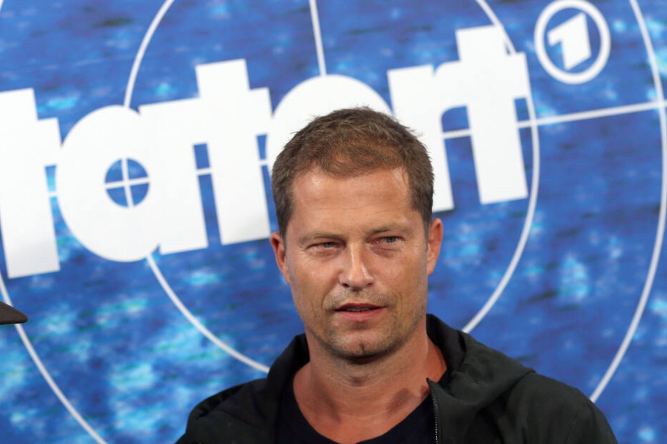 Der Schauspieler Til Schweiger steht vor einer Stellwand mit dem "Tatort"-Logo.
