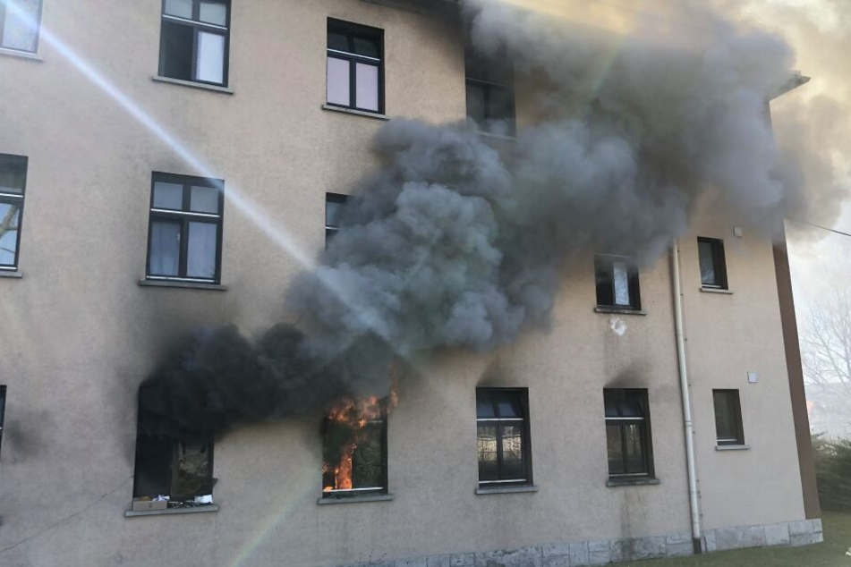Schwarzer Rauch steigt aus einem Fenster der Unterkunft empor.
