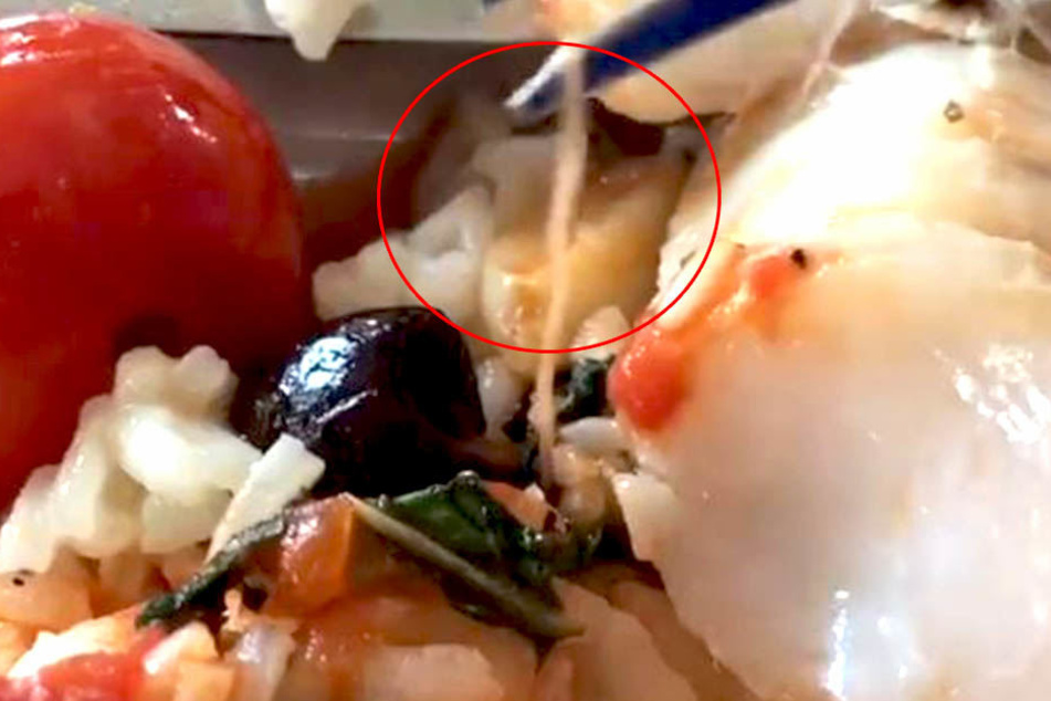 In ihrem Essen entdeckte einen Frau einen Parasiten. Der Mann filmt den ungewünschten Essensinhalt.