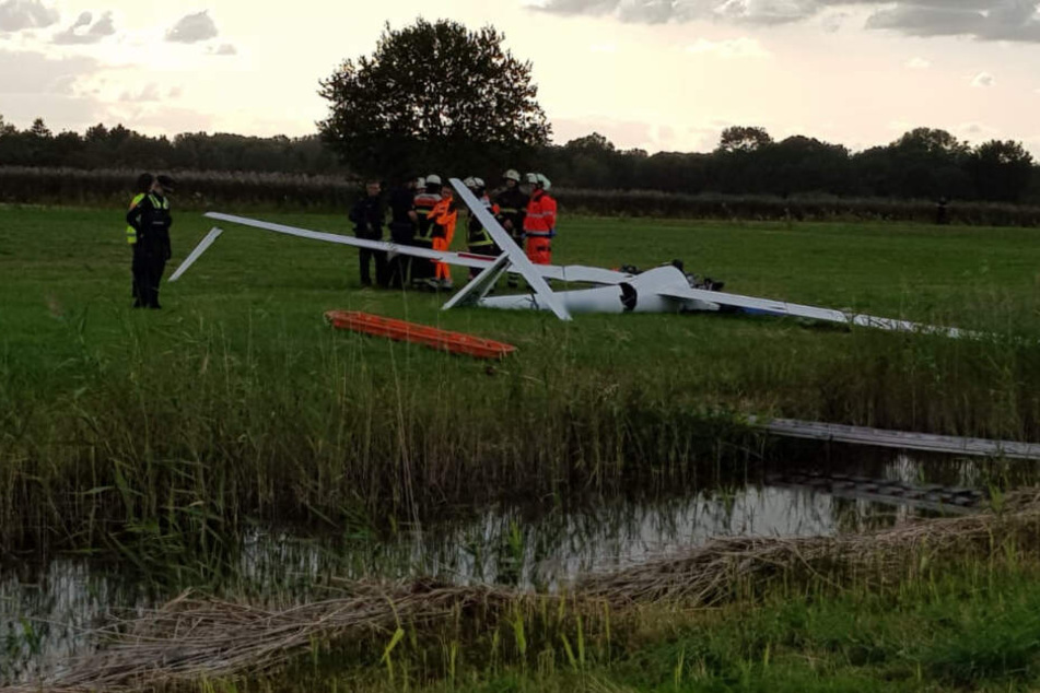 Einsatzkräfte stehen neben dem abgestürzten Segelflieger.