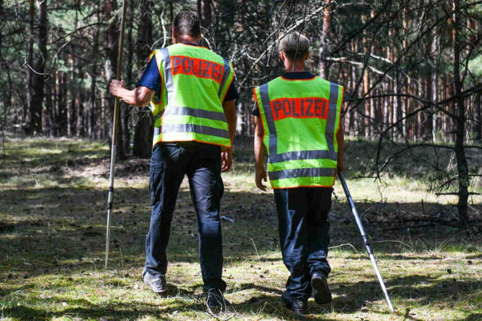 Zwei Polizisten suchen in einem Waldstück nach der vermissten Rebecca.