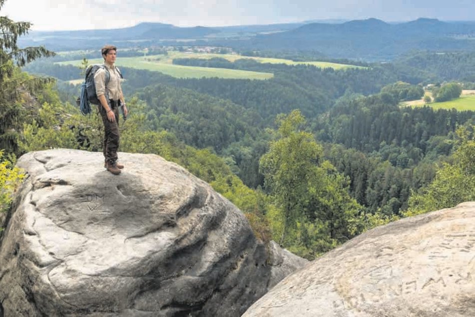 Ranger Jonas (Philipp Danne) lässt hoch oben auf dem Fels den Blick über die herrliche Landschaft schweifen.
