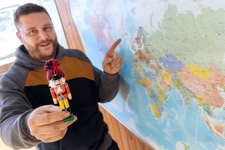 Spielzeugmacher Markus Füchtner (36) zeigt auf einer Karte die Länder, welche sein Mini-Nussknacker schon bereist hat.