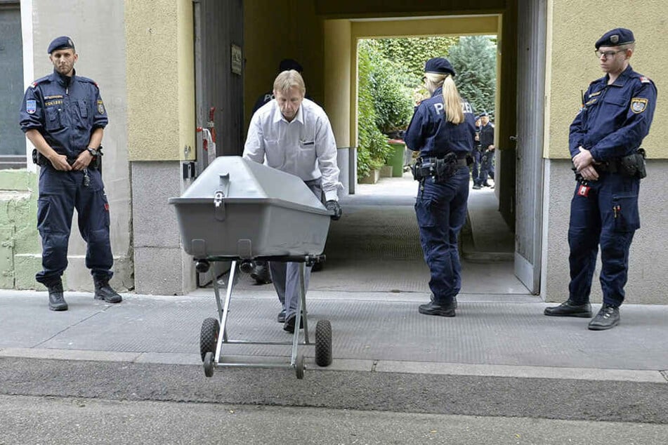 Die Leiche des getöteten Mädchens wird in einem Sarg aus einer Wohnhausanlage in Wien gebracht und in einen Leichenwagen gehoben.