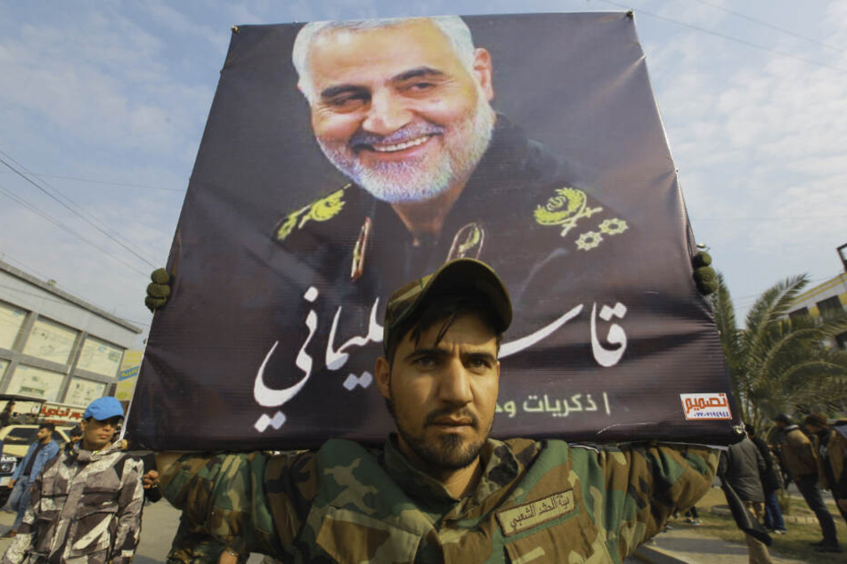 Ein Mann trägt ein Bild des getöteten iranischen Generals Soleimani während eines Trauerzugs in Bagdad.