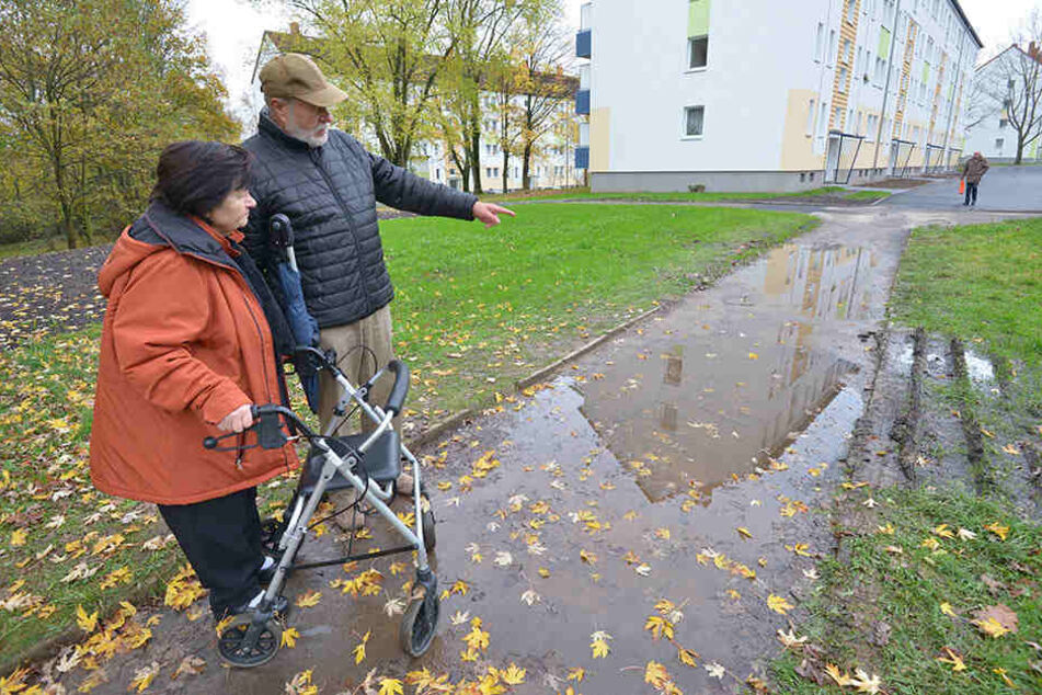 Die Anwohner Gisela Aumann (77) und Claus Modaleck (77) ärgern sich über den bei Regen unpassierbaren Fußweg.