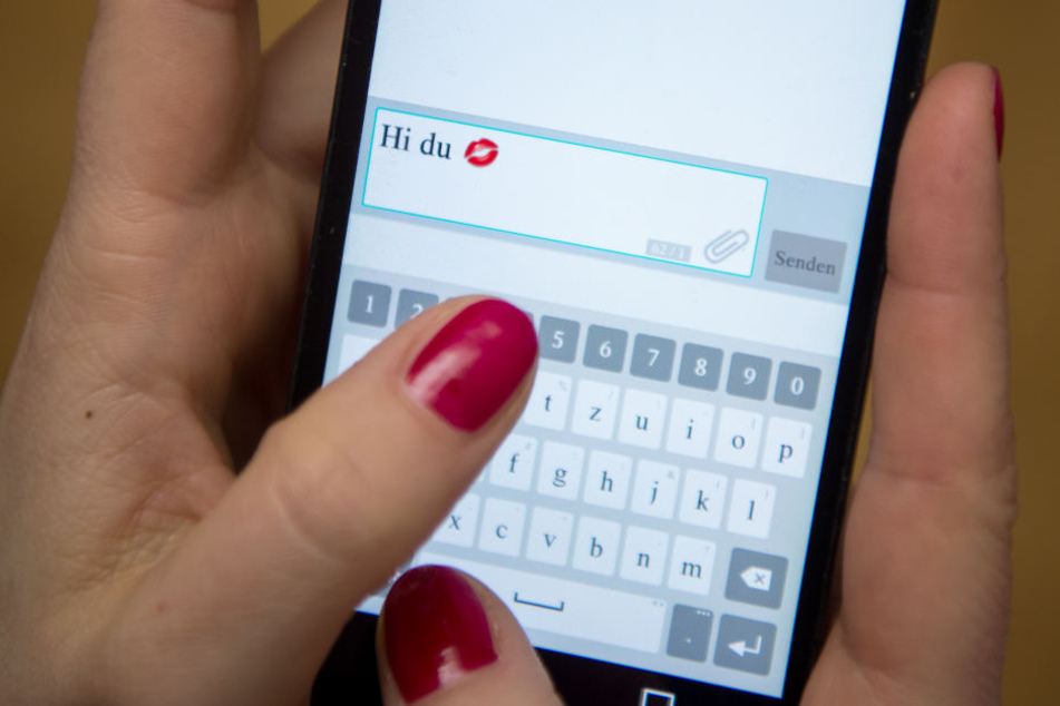 Eine Frau tippt auf einem Smartphone eine Nachricht. (Symbolbild)