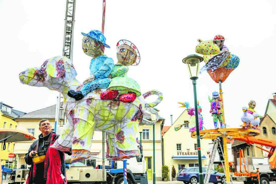 Kranführer Stefan Zscherpe (62) bugsiert die bunte Künstlerfigur zum weihnachtlichen Figurenbaum, der vor dem Goldenen Anker in Altkötzschenbroda aufgebaut wird.